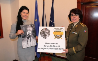 Symbolické předání šeku, Tereza Knihová (vlevo) drží v ruce kalendář, výtěžek z jeho prodeje předala Vojenskému fondu solidarity. 